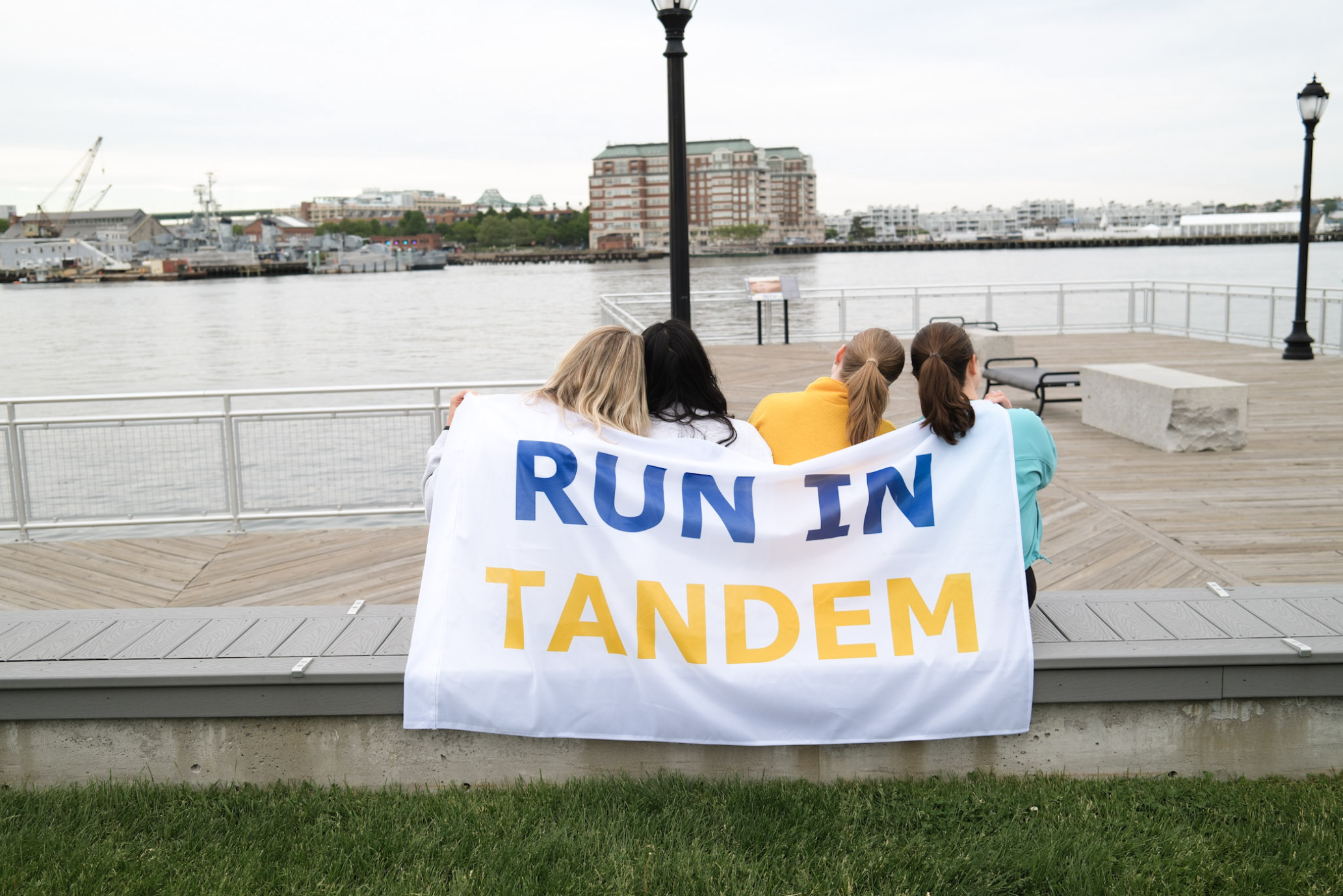Two women holding a finish-line flag together after a race.