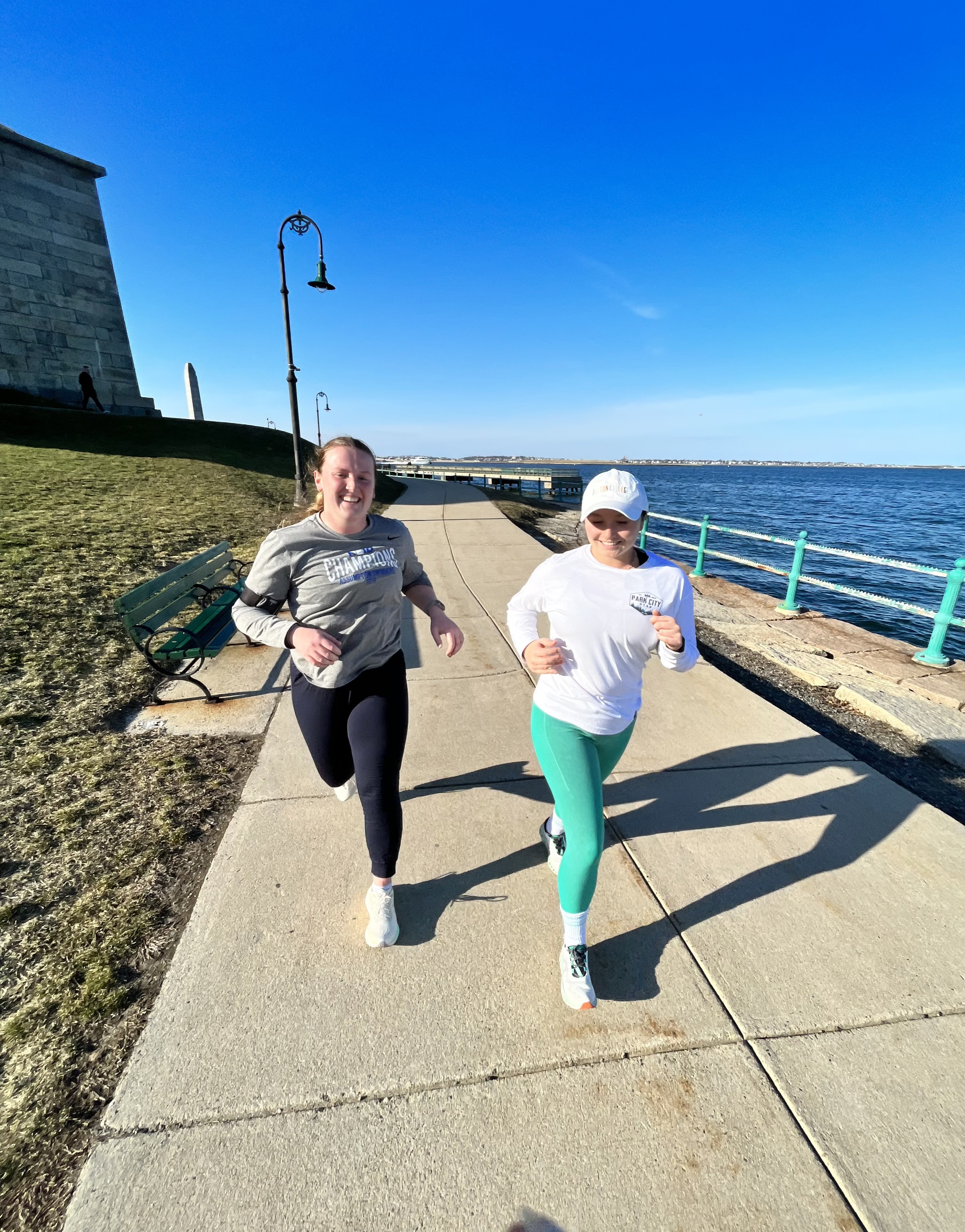 Two women running together at castle island